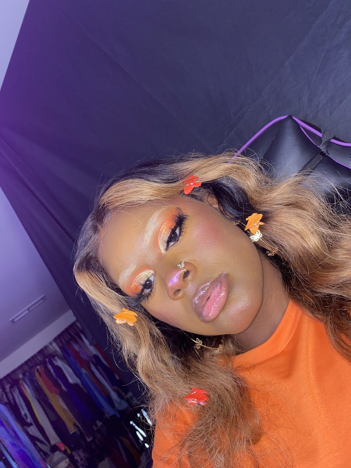 Orange eyeshadow look with butterfly earrings